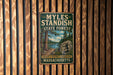 A vintage metal sign for the state forest in Massachusetts, featuring a scenic illustration of a forest and a river.