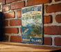 A vintage-style metal sign for Narragansett Bay, Rhode Island, featuring illustrations of a sailboat, a crane, and a heron.