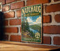 A vintage metal sign for the Natchaug State Forest in Connecticut, featuring a scenic landscape with pine trees and a lake.