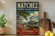 A vintage-style poster of the Mississippi River with a steamboat, surrounded by a house and flowers, is displayed on a wall next to a wooden cutting board and a potted plant.