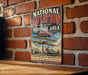 A vintage-style metal sign with the text "NATIONAL AVIATION HERITAGE AREA OHIO" and an illustration of a biplane on a brick wall.