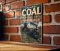 A vintage-style metal sign for the National Coal Heritage Area in Pennsylvania, featuring an illustration of a coal train and a scenic landscape.