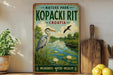 A vintage-style metal sign for "Kopacki Rít" in Croatia, featuring a heron and a boat on a lake surrounded by greenery.
