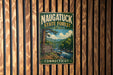 A vintage metal sign for the Naugatuck State Forest in Connecticut, featuring a scenic image of a forest and a river.