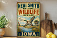 A vintage-style sign for the Neal Smith National Wildlife Refuge in Iowa, featuring a duck in flight and a scenic landscape.