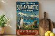 A vintage-style sign advertising the Sub-Antarctic Islands in New Zealand, featuring a penguin, seal, and other wildlife in a scenic landscape.