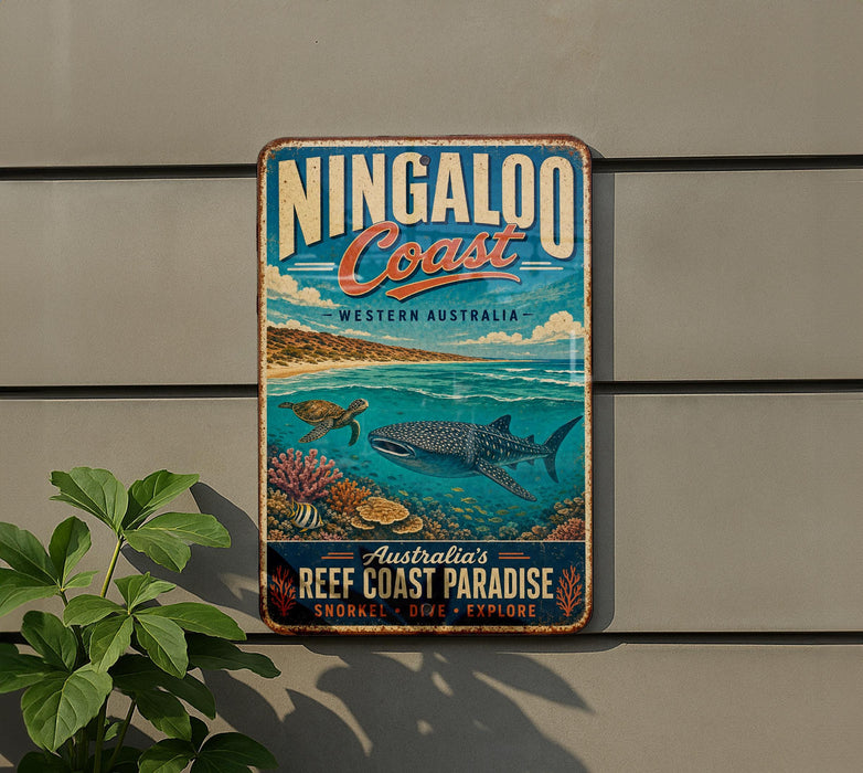 A vintage-style metal sign for the Ningaloo Coast in Western Australia, featuring an illustration of a whale, coral, and other marine life.