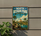 A vintage-style metal sign for North Riyadh Park in Saudi Arabia, featuring a scenic illustration of palm trees, a river, and a tent-like structure.