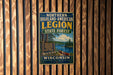 A vintage-style metal sign for the Northern Highland-American Legion State Forest in Wisconsin, featuring a scenic image of a lake and forest.