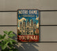 A vintage metal sign with the text "NOTRE-DAME CATEDRALE" and "TOURNAI BELGIQUE" is displayed on a wall, with a plant to the left.