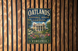 A vintage-style metal sign for the Oatlands Historic House & Gardens in Virginia, featuring a house surrounded by a well-maintained garden with flowers and plants.