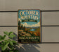 A vintage metal sign for October Mountain State Forest in Massachusetts, featuring a scenic landscape with mountains, trees, and a river.
