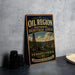A vintage-style sign for the Pennsylvania National Heritage Area, featuring an illustration of a town and a tower, with the text "OIL REGION NATIONAL HERITAGE AREA PENNSYLVANIA" prominently displayed.