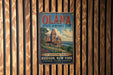 A vintage metal sign for the Olana State Historic Site in Hudson, New York, featuring an illustration of a castle-like building surrounded by trees and a river.
