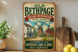 a vintage-style sign for "Old Bethpage Village Restoration" in New York, with a depiction of a windmill and a house, along with the text "Step back in time" and "Experience Long Island's rich heritage".