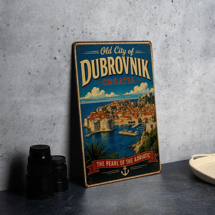 A vintage metal sign displaying the text "Old City of Dubrovnik, Croatia" and an illustration of the city's waterfront, with a banner that reads "The Pearl of the Adriatic".