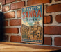 a vintage-style sign for the "Old City of Sana'a" in Yemen, mounted on a brick wall.