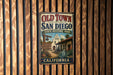 A vintage-style metal sign for Old Town San Diego, California, featuring a sign with a bell and welcoming visitors to the state historic park.