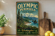 A vintage-style metal sign for Olympic Peninsula State Forest, featuring a scenic landscape with mountains, pine trees, and a body of water.
