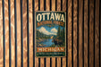 A vintage metal sign for the Ottawa National Forest in Michigan, featuring a moose and a forest landscape.