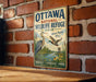 A vintage metal sign for the Ottawa National Wildlife Refuge in Ohio, featuring illustrations of birds and a serene landscape.