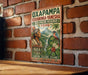 a vintage-style sign with a colorful illustration of a native Peruvian figure, surrounded by lush tropical foliage and a waterfall. The sign is mounted on a brick wall and appears to be a decorative piece.