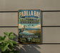 A vintage-style metal sign for Padilla Bay National Estuarine Research Reserve, featuring a bird and a scenic landscape.