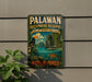 A vintage-style sign for the Palawan Biosphere Reserve in the Philippines, featuring a tropical landscape with a bird, a boat, and lush vegetation.
