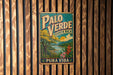 A vintage metal sign with the text "PALO VERDE" and "COSTA RICA" is displayed on a wooden wall.