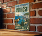 A vintage metal sign for the Parc National de Anticosti in Quebec, featuring a deer and a coastal landscape.