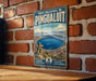 A vintage-style metal sign for the Porc National de Pingualuit in Quebec, featuring a scenic image of the lake and surrounding landscape.