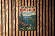 A vintage metal sign for the park, featuring a scenic landscape with mountains, a river, and pine trees.