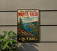 A vintage-style metal sign with a scenic mountain landscape and a river, mounted on a wall.