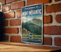 A vintage-style metal sign with the text "PARC NATIONAL DU MONT-MEGANTIC" and "QUÉBEC CANADA" is displayed on a brick wall.