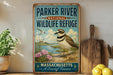 A vintage-style metal sign for the Parker River National Wildlife Refuge in Massachusetts, featuring a bird and a coastal landscape.