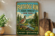 A vintage-style metal sign for the Partridge Run State Forest in New York, featuring a bird and a forest landscape.