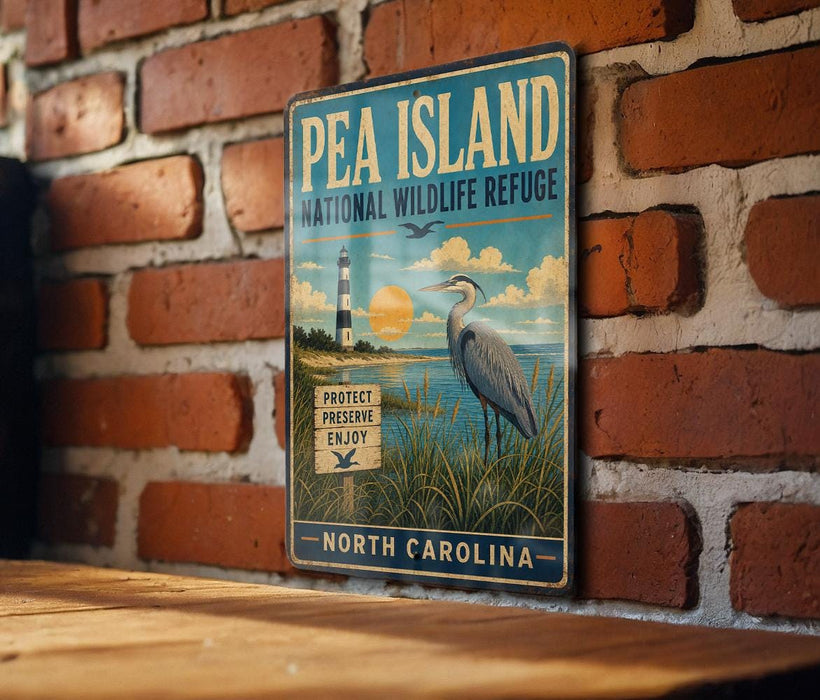 A vintage-style metal sign for Pea Island National Wildlife Refuge in North Carolina, featuring a lighthouse and a bird in the foreground.