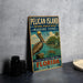 A vintage-style metal sign for Pelican Island National Wildlife Refuge, featuring an illustration of a pelican and a marine scene, is displayed on a gray countertop.