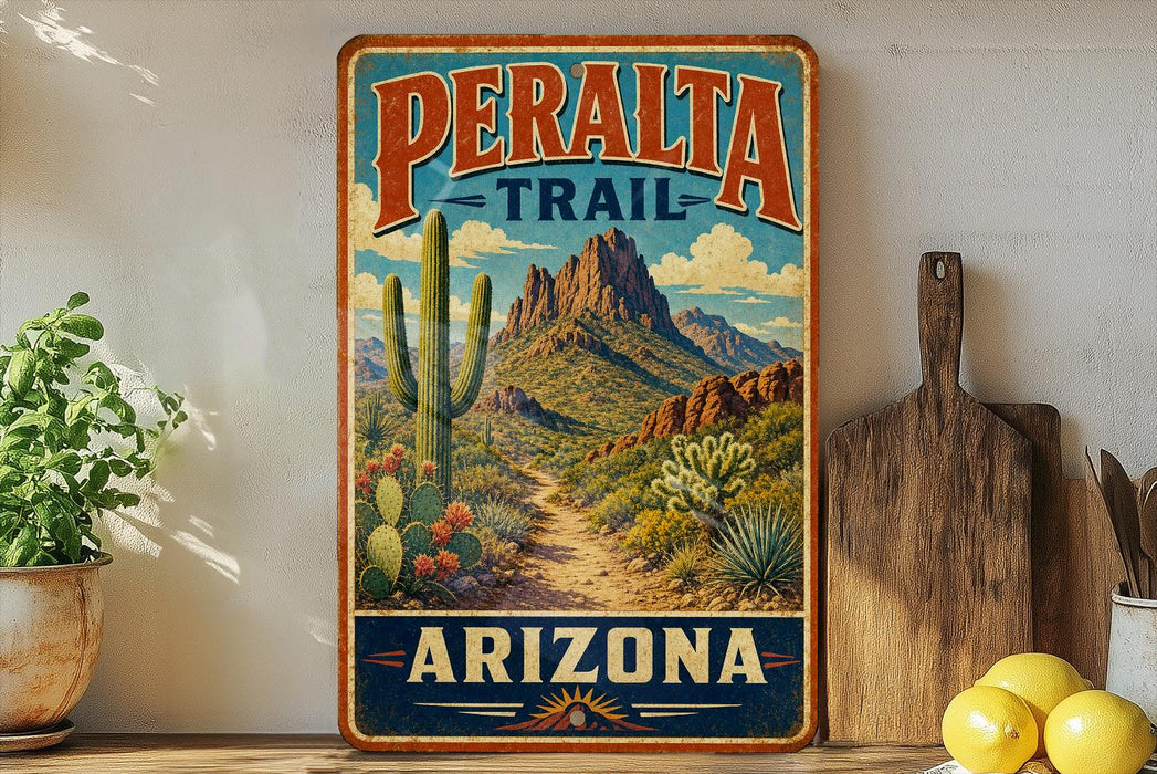 A vintage-style metal sign for the Peralta Trail in Arizona, featuring a desert landscape with mountains, cacti, and a winding path.