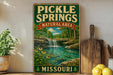 A vintage-style sign for Pickle Springs Natural Area in Missouri, featuring a scenic landscape with a waterfall and lush greenery.