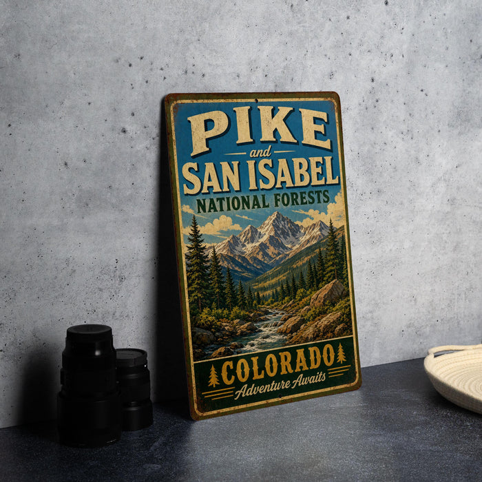 A vintage-style metal sign for Pike and San Isabel National Forests in Colorado, featuring a scenic mountain landscape.