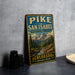 A vintage-style metal sign for Pike and San Isabel National Forests in Colorado, featuring a scenic mountain landscape.