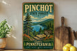 A vintage-style metal sign for the Pinchot State Forest in Pennsylvania, featuring a scenic landscape with pine trees, a lake, and mountains.