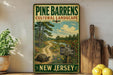 A vintage-style sign for Pine Barrens Cultural Landscape in New Jersey, featuring a scenic illustration of a forest and a winding path.
