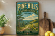 A vintage-style sign for Pine Hills Nature Preserve in Indiana, featuring a scenic landscape with a winding path and pine trees.