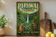 A vintage-style poster advertising the "Pipiai Trail" in Hawaii, featuring a scenic waterfall surrounded by lush tropical foliage.