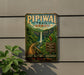 A vintage-style metal sign for the Pipiwai Trail in Hawaii, featuring a waterfall and lush greenery.