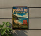 A vintage-style metal sign for Pistolet Bay Provincial Park, featuring a scenic coastal landscape with a beach, mountains, and a body of water.