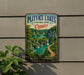 A vintage-style sign for Plitvice Lakes National Park in Croatia, featuring a scenic landscape with waterfalls and lush greenery.