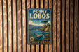 A vintage metal sign for Point Lobos State Marine Reserve in California, featuring an illustration of a rocky coastline, a tree, and marine life.